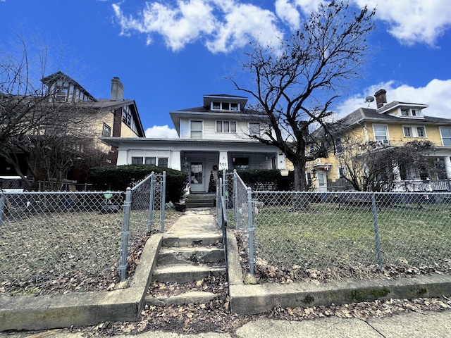 american foursquare style home featuring a fenced front yard and a gate