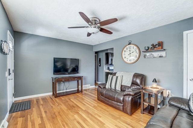 living room featuring ceiling fan and light wood-type flooring