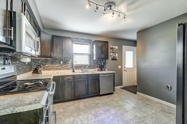 kitchen with appliances with stainless steel finishes, sink, backsplash, and dark brown cabinetry