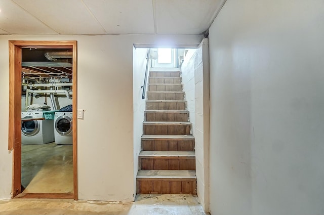 stairs featuring separate washer and dryer and concrete floors