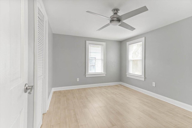 unfurnished room with ceiling fan, light wood finished floors, and baseboards