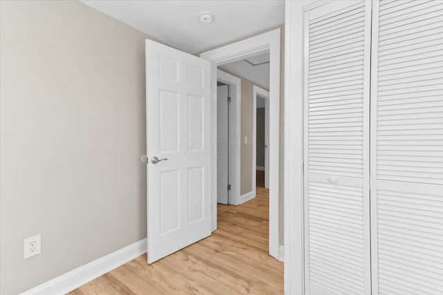 hall with light wood finished floors and baseboards