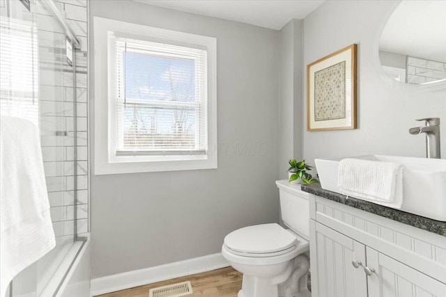 full bath featuring visible vents, toilet, shower / tub combination, wood finished floors, and baseboards