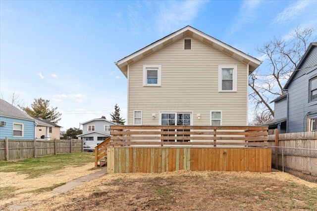 back of property featuring a fenced backyard, a deck, and a yard