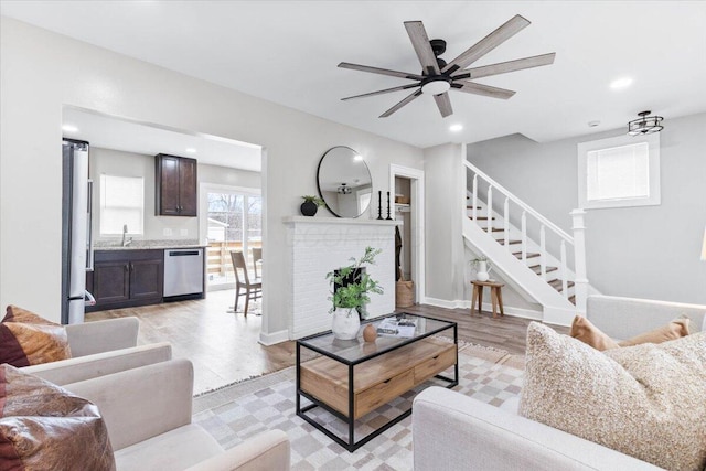 living area with light wood-style floors, recessed lighting, baseboards, and stairs