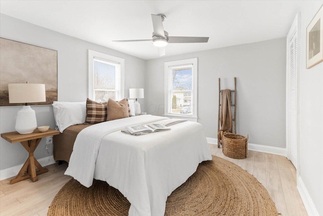 bedroom featuring light wood-style flooring, baseboards, and ceiling fan