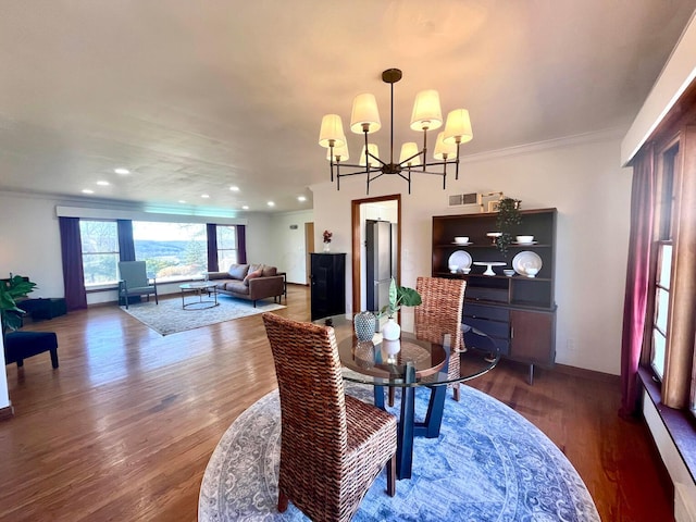 dining space with ornamental molding, dark hardwood / wood-style floors, and a chandelier