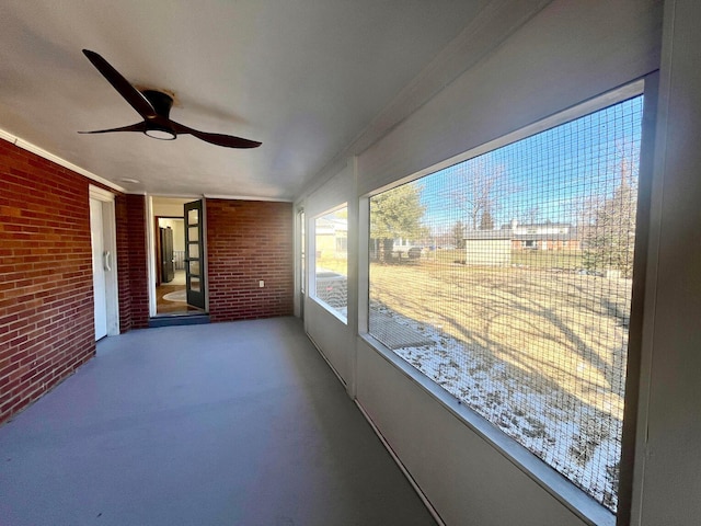 unfurnished sunroom with ceiling fan