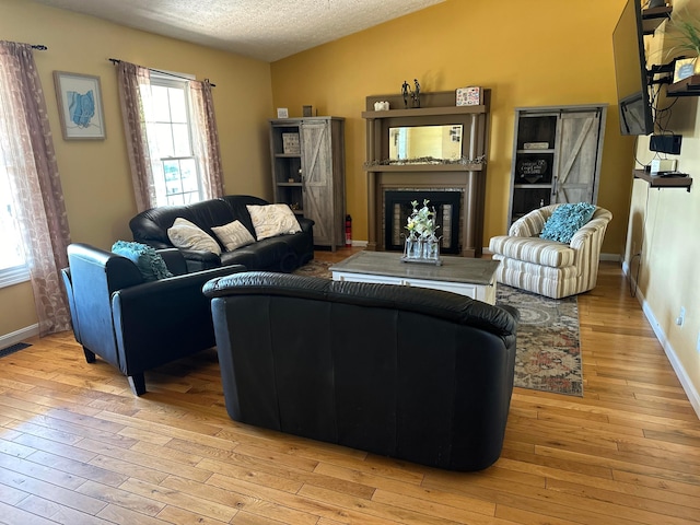1048 Parkway Dr, Logan, OH 43138 - living area with light wood-style floors, a fireplace, visible vents, and a textured ceiling
