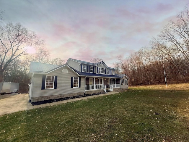 view of front facade with a lawn and covered porch