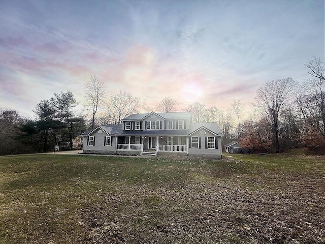 view of front of home with a porch and a yard