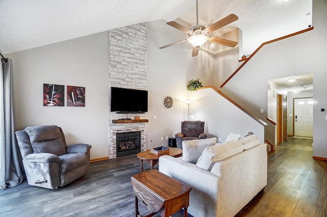 living room with a fireplace, dark wood-type flooring, high vaulted ceiling, and ceiling fan