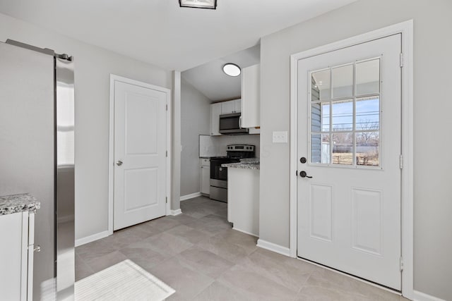 kitchen with white cabinetry, appliances with stainless steel finishes, and light stone countertops