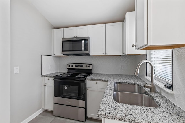 kitchen featuring light stone counters, sink, white cabinets, and appliances with stainless steel finishes