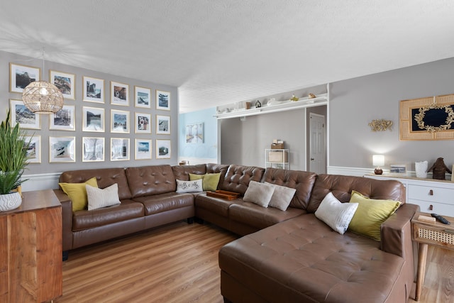 living room featuring a textured ceiling and light hardwood / wood-style flooring