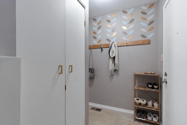 bathroom featuring tile patterned flooring and a textured ceiling