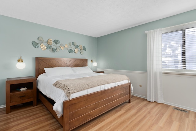 bedroom featuring light wood-type flooring and a textured ceiling