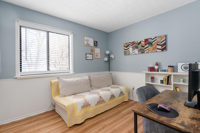 bedroom with light hardwood / wood-style floors and a textured ceiling