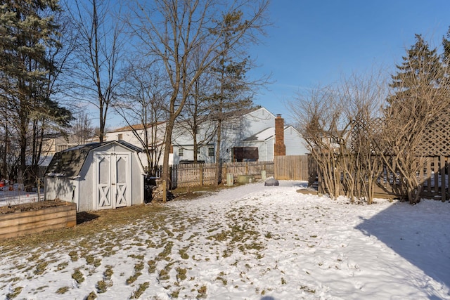 snowy yard featuring a storage shed