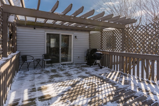 snow covered deck featuring a pergola and a grill