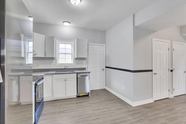 kitchen featuring sink, electric range oven, tasteful backsplash, white cabinets, and stainless steel dishwasher