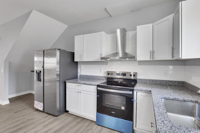 kitchen with white cabinetry, stainless steel appliances, backsplash, and wall chimney range hood