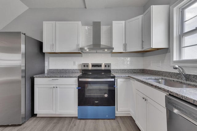 kitchen with white cabinetry, wall chimney exhaust hood, and appliances with stainless steel finishes