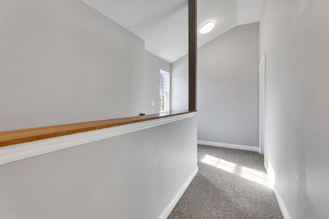 hall featuring lofted ceiling and carpet