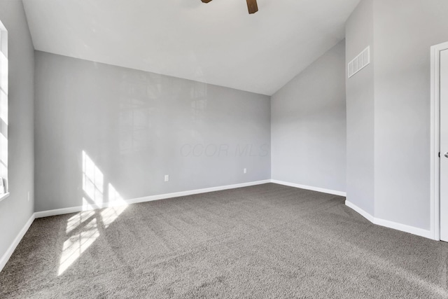 empty room with dark colored carpet, lofted ceiling, and ceiling fan