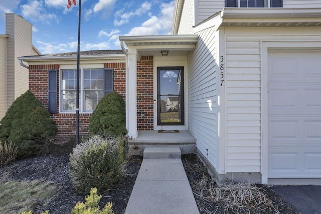 view of exterior entry featuring brick siding