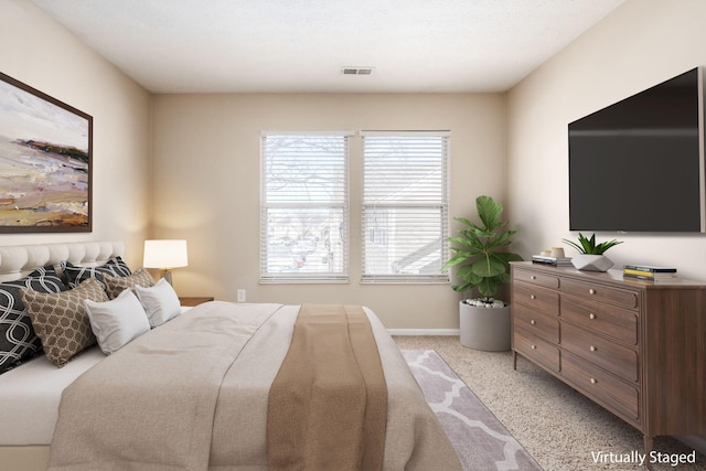 bedroom with light carpet, visible vents, and baseboards