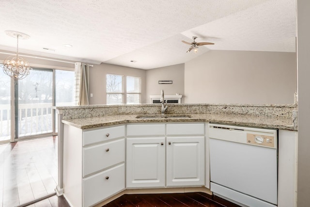 kitchen featuring white cabinetry, white dishwasher, a sink, a peninsula, and ceiling fan with notable chandelier