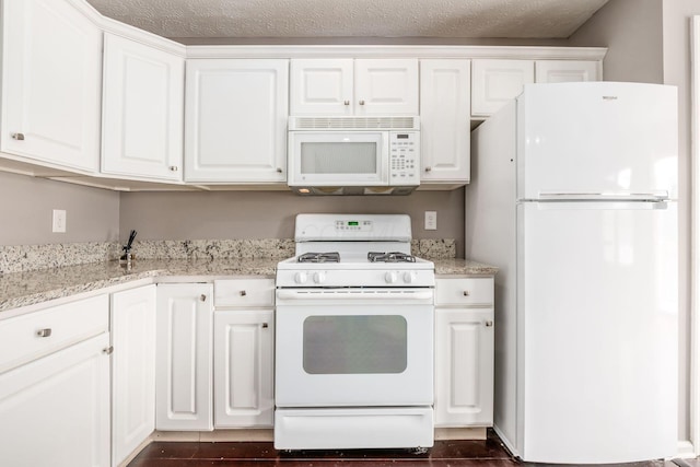 kitchen with white appliances, dark wood-style floors, white cabinetry, and light stone counters