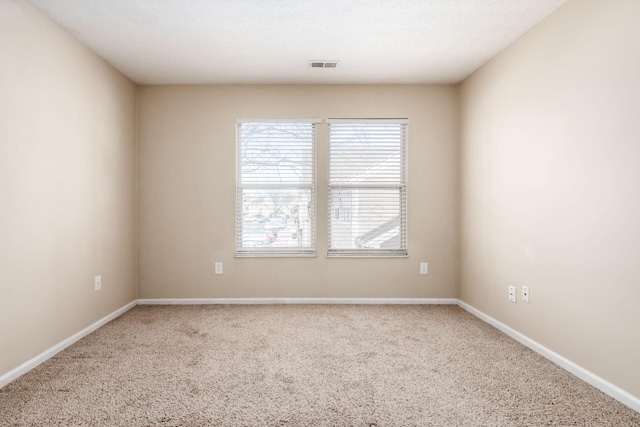 carpeted empty room with visible vents and baseboards