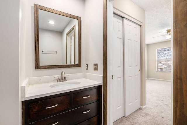 bathroom featuring ceiling fan, baseboards, a closet, and vanity