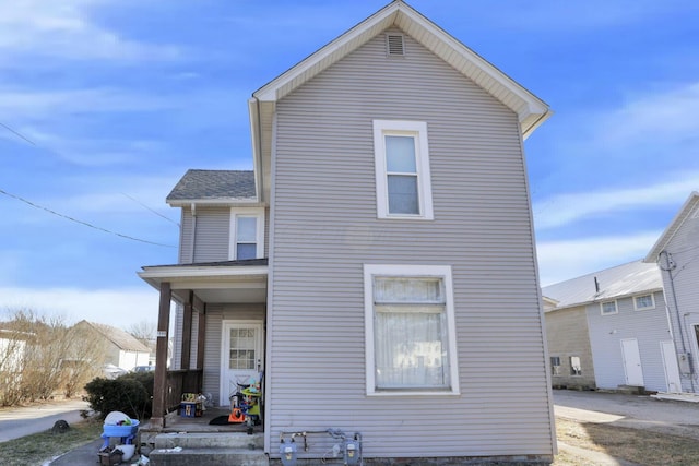 rear view of property with covered porch