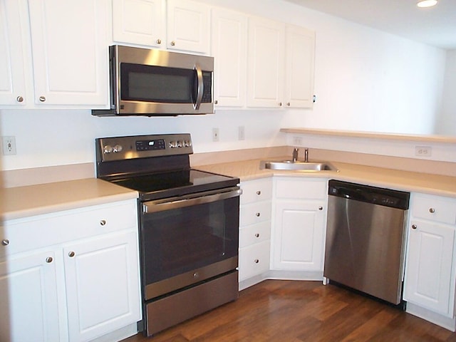 kitchen with light countertops, appliances with stainless steel finishes, a sink, and white cabinetry