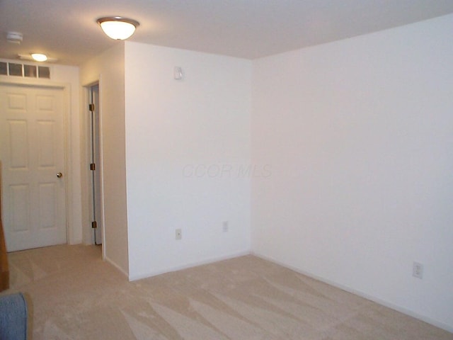 unfurnished room with light colored carpet and visible vents