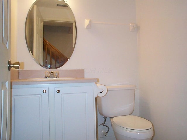 half bathroom featuring toilet and vanity