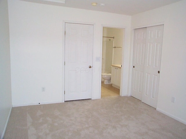 unfurnished bedroom with light carpet and ensuite bathroom