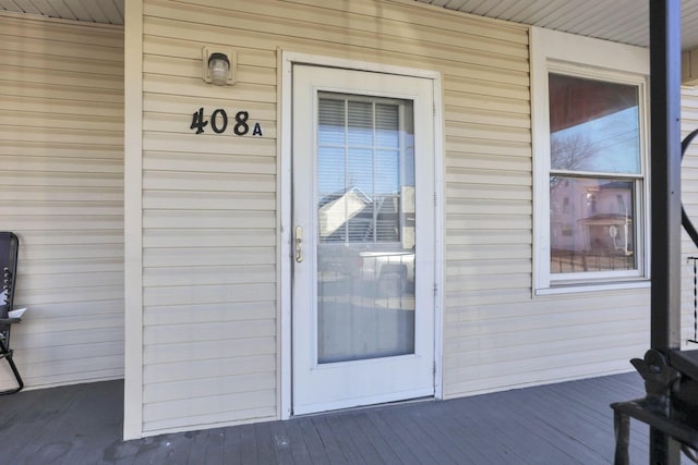 view of exterior entry featuring covered porch