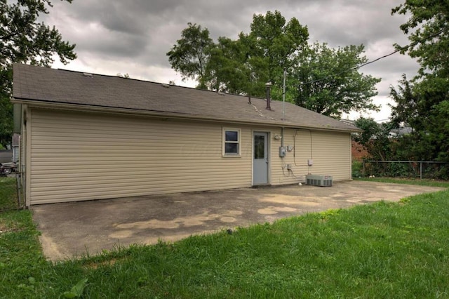 back of house featuring a patio area, central AC, fence, and a lawn