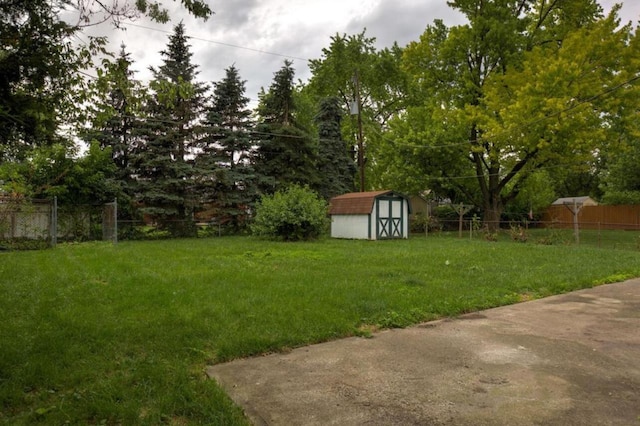 view of yard with an outdoor structure, fence, and a shed