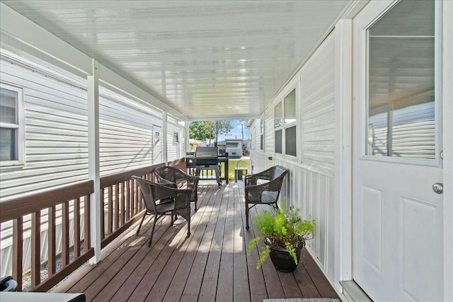 wooden terrace featuring grilling area and a porch