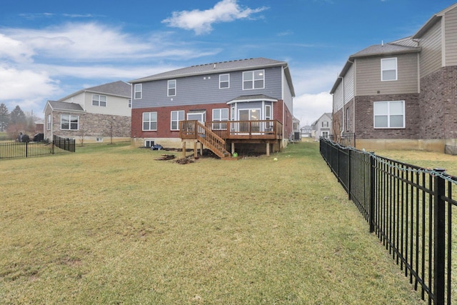 back of property with a wooden deck and a lawn