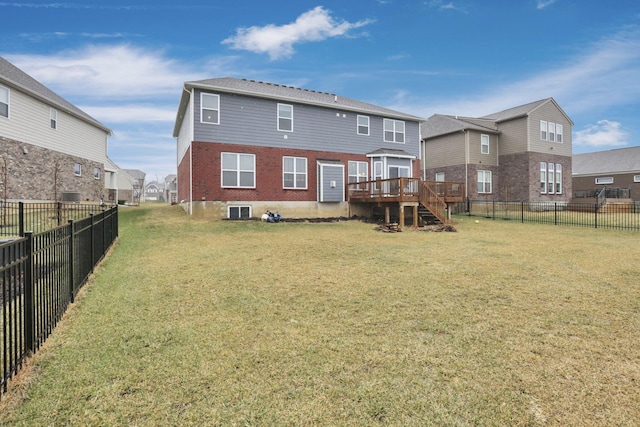 rear view of house with a wooden deck and a yard