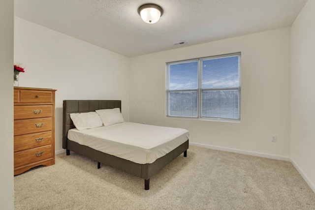 carpeted bedroom featuring a textured ceiling