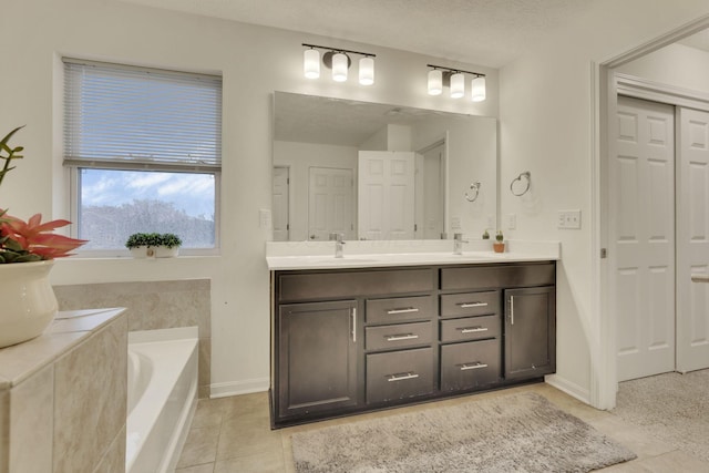 bathroom with vanity, tiled bath, tile patterned floors, and a textured ceiling