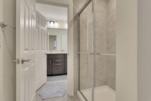 bathroom with vanity, tile patterned floors, a textured ceiling, and walk in shower