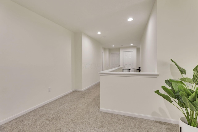 corridor featuring light colored carpet